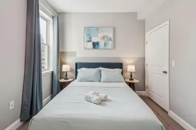 a bedroom with a large white bed with two lamps at Stay at Luna on N 11th St in Philadelphia