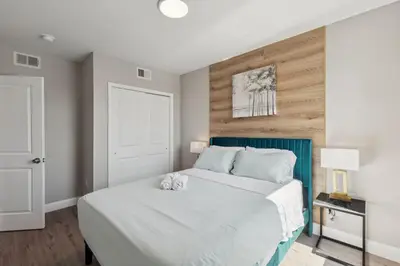 a bedroom with a white bed with a blue headboard at Stay at Luna on N 11th St in Philadelphia