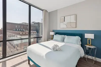 a bedroom with a large bed and a large window at Stay at Luna on N 11th St in Philadelphia