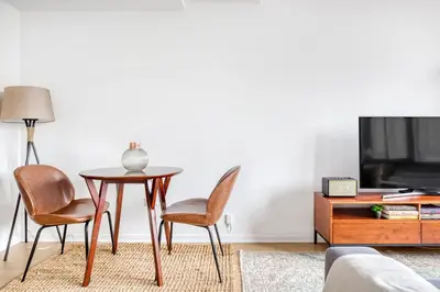 a living room with a table and chairs and a tv at Tribeca Studio Indoor pool Great views NYC-185 in New York