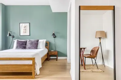 a bedroom with blue walls and a bed and a chair at Tribeca Studio Indoor pool Great views NYC-185 in New York