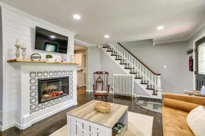 a living room with a fireplace and a staircase at Bright Cornwall-On-Hudson Vacation Rental! in Cornwall-on-Hudson