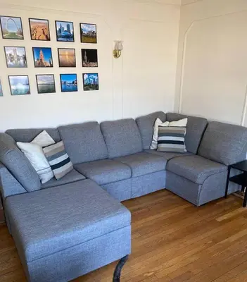 a living room with a blue couch and pictures on the wall at Comfy stay – sleeps 4 (Hoboken) in Hoboken