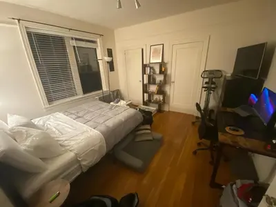 a bedroom with a bed and a desk with a camera at Comfy stay – sleeps 4 (Hoboken) in Hoboken
