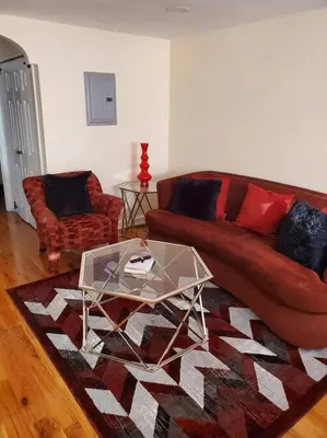 a living room with a red couch and a glass table at Cozy 2-bedroom Apartment in Philadelphia