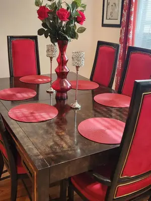 a dining room table with red chairs and a vase with roses at Cozy 2-bedroom Apartment in Philadelphia