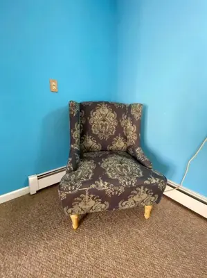 a chair in a room with a blue wall at Peddlers Carriage house in New Hope