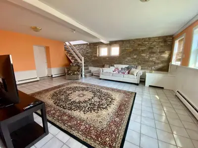 a living room with a couch and a stone wall at Peddlers Carriage house in New Hope