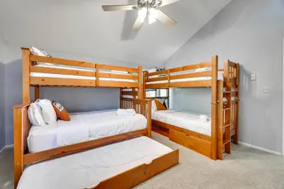 two bunk beds in a room with a ceiling fan at Lake Harmony Home Near Big Boulder! in Lake Harmony