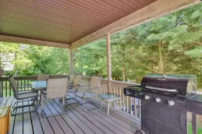 a screened in porch with a grill and chairs at Lake Harmony Home Near Big Boulder! in Lake Harmony