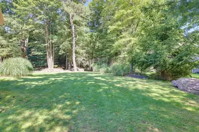 a large grassy yard with trees in the background at Lake Harmony Home Near Big Boulder! in Lake Harmony