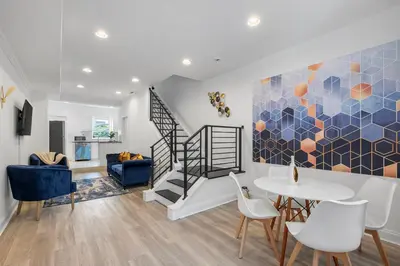 a living room with a staircase and a table and chairs at Luxury 3BR Townhome - Northern Liberty in Philadelphia