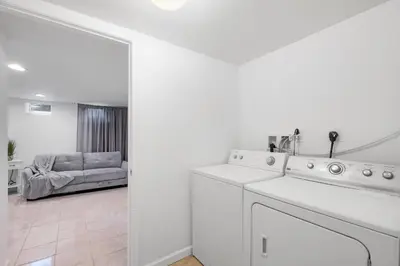 a white kitchen with a sink and a living room at Luxury 3BR Townhome - Northern Liberty in Philadelphia