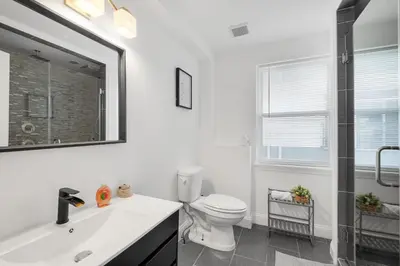 a bathroom with a toilet and a sink and a mirror at Luxury 3BR Townhome - Northern Liberty in Philadelphia