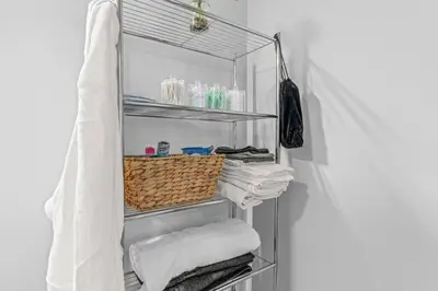 a towel rack with towels and a basket on it at Pure Relaxation-Luxury/Roof Top* in Philadelphia