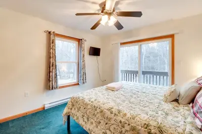a bedroom with a bed and a ceiling fan at Less Than 1 Mi to Ski Hill! Poconos Retreat with Game Room in Pocono Lake