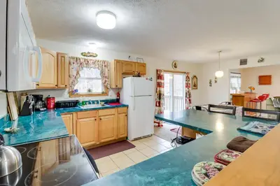 a kitchen with wooden cabinets and a white refrigerator at Less Than 1 Mi to Ski Hill! Poconos Retreat with Game Room in Pocono Lake