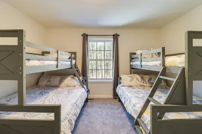 two bunk beds in a room with a window at 3 Mi to Kalahari Pocono Summit Home with Pool Table in Pocono Summit