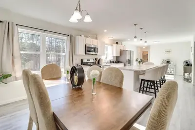 a kitchen and dining room with a wooden table and chairs at 3 Mi to Kalahari Pocono Summit Home with Pool Table in Pocono Summit