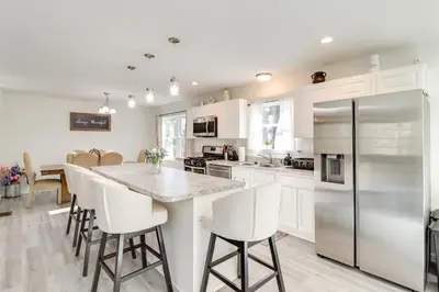 a kitchen with white cabinets and a stainless steel refrigerator at 3 Mi to Kalahari Pocono Summit Home with Pool Table in Pocono Summit