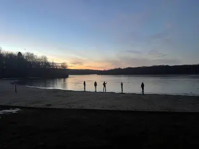 a group of people standing on a beach near the water at Poconos Peaceful Retreat - Families & Large Groups in Tobyhanna