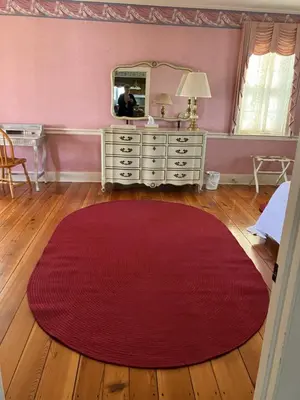 a room with a red rug and a dresser with a mirror at Farmhouse at Landyshade in Lancaster