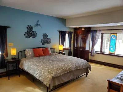 a bedroom with a bed with blue walls and windows at Spacious Gateway, Walk to POOL & BEACH, Hot tub, Game room in Pocono Country Place