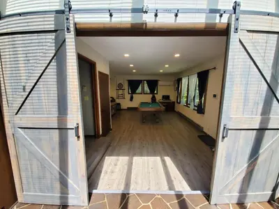 an open door leading to a living room with wooden floors at Spacious Gateway, Walk to POOL & BEACH, Hot tub, Game room in Pocono Country Place
