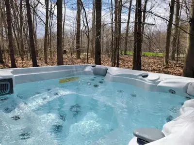 a hot tub in the middle of the woods at Spacious Gateway, Walk to POOL & BEACH, Hot tub, Game room in Pocono Country Place