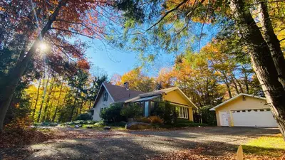 a house with a driveway in the fall at Spacious Gateway, Walk to POOL & BEACH, Hot tub, Game room in Pocono Country Place