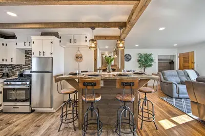 a kitchen with a large island with bar stools at Marietta Home with Private Hot Tub, Pool Table! in Marietta
