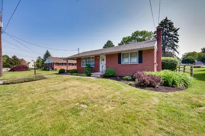 a red brick house with a grass yard at Marietta Home with Private Hot Tub, Pool Table! in Marietta