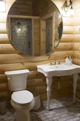 a bathroom with a toilet and a sink and a mirror at Log Country Inn Bed and Breakfast of Ithaca in Spencer