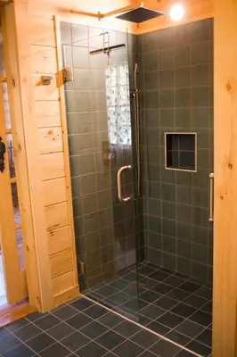 a bathroom with a shower with green tile at Log Country Inn Bed and Breakfast of Ithaca in Spencer