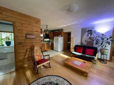 a living room with a couch and a kitchen at Log Country Inn Bed and Breakfast of Ithaca in Spencer