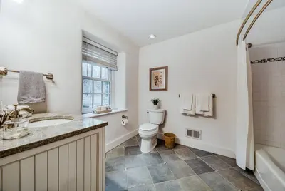 a bathroom with a toilet and a sink and a tub at The Stone House on Main Street in Stockton