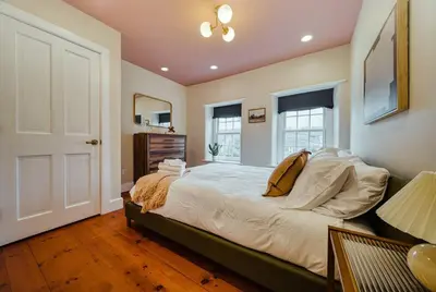 a bedroom with a large bed and two windows at The Stone House on Main Street in Stockton