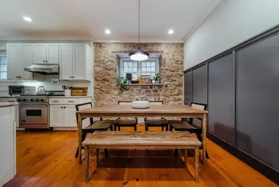 a kitchen with a wooden table and chairs in it at The Stone House on Main Street in Stockton