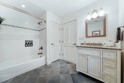 a white bathroom with a tub and a sink at The Stone House on Main Street in Stockton