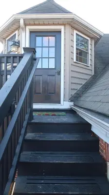 a staircase leading to a house with a door at Creative Private Attic 1br Suite in Honey Brook