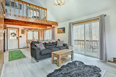 a living room with a couch and a table at 4 Mi to Tubing Cozy Bushkill Cabin with Deck! in Bushkill