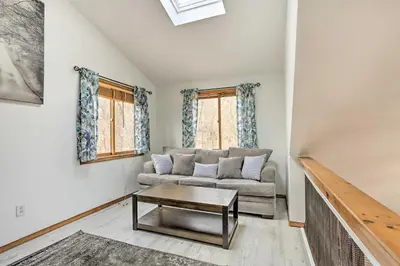 a living room with a couch and a table at 4 Mi to Tubing Cozy Bushkill Cabin with Deck! in Bushkill