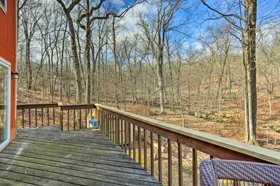a wooden deck with a view of the woods at 4 Mi to Tubing Cozy Bushkill Cabin with Deck! in Bushkill