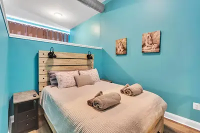 a bedroom with blue walls and a bed with two pillows at Broad Street Apartment in Philadelphia