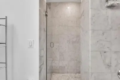a shower with a glass door in a bathroom at Broad Street Apartment in Philadelphia