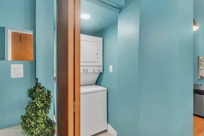 a kitchen with a white refrigerator and a plant at Broad Street Apartment in Philadelphia