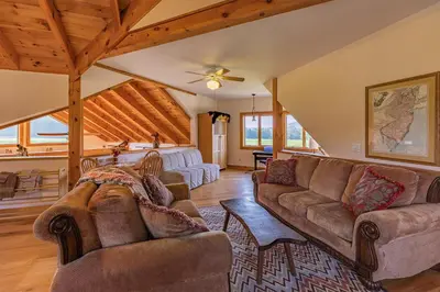 a living room with couches and a ceiling at Tenwood Lodge in Ithaca