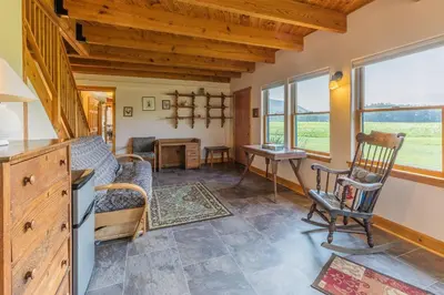 a living room with a table and a chair at Tenwood Lodge in Ithaca
