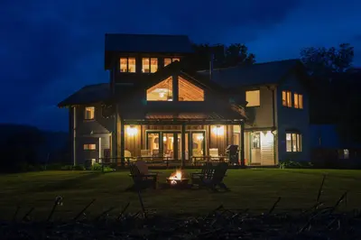 a house with a fire in the yard at night at Tenwood Lodge in Ithaca