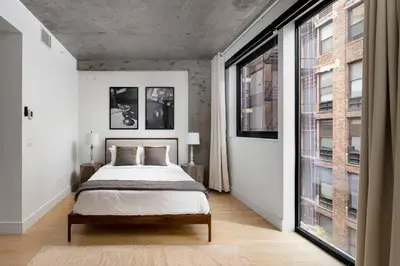a bedroom with a bed and a large window at Stunning Penthouse in Chelsea in New York